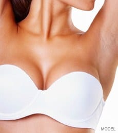 Woman's enhanced breasts in white bra