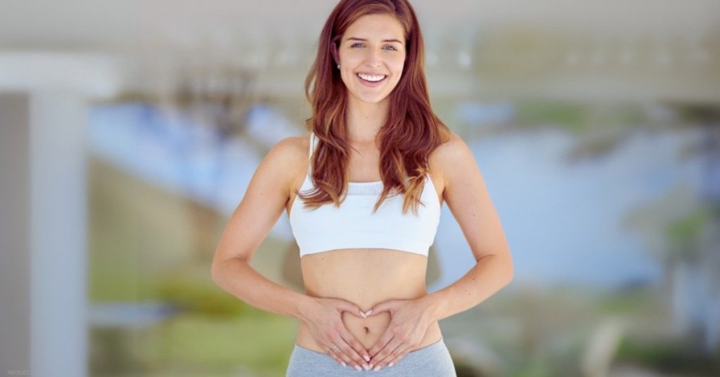 A woman with her hands on her stomach (model)