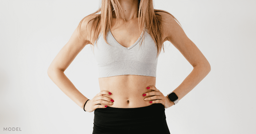 A woman wearing a sports bra and work out clothes (model)