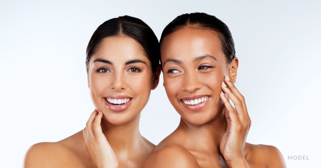 Two beautiful woman with flawless glowing skin are smiling. (Models)